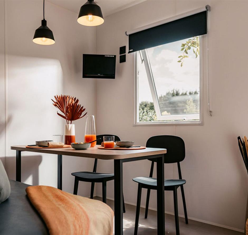 Esszimmer mit Sofa und Tisch in einem 5-Sterne-IRM-Cottage - Camping pomme de pin
